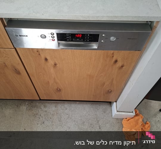 מדיח כלים בוש במטבח עם מגבת כתומה על הרצפה